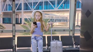 年轻的女孩移动电话手提箱等待离开休息室机场